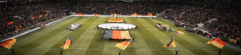 Ein großes Fußballstadion voller Zuschauer mit vielen wehenden Deutschlandflaggen